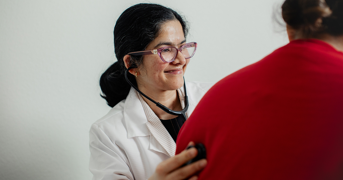 Dr. Singh listens to a patient's breathing with a stethoscope.