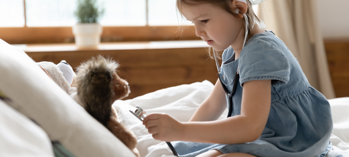 child using a stethoscope on a stuffed animal