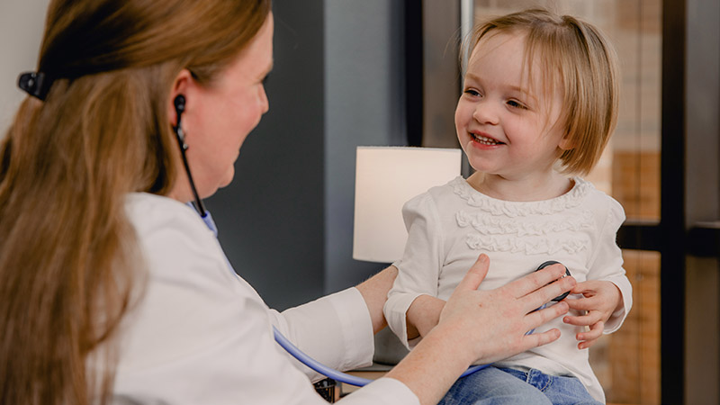 Provider using stethoscope on child patients heart