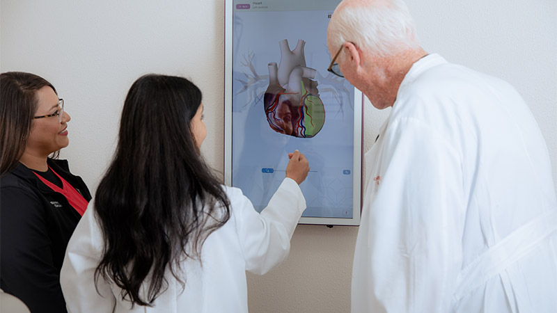 Providers looking at digital screen of a heart