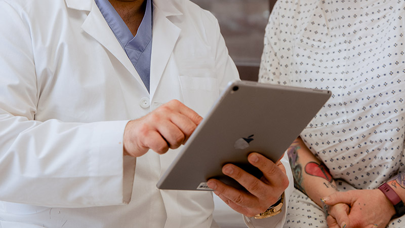 Provider with tablet in hands showing patient