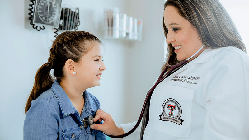 Provider checking a child's heart with stethoscope.